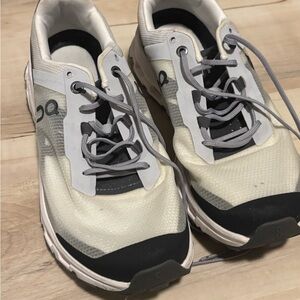 On Running Cream and Black Sneakers